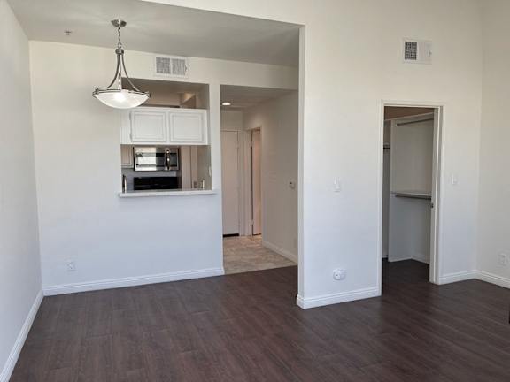 A room with a kitchenette and a doorway leading to another room.