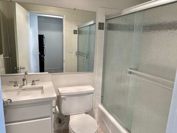 A white toilet sits next to a sink in a bathroom.
