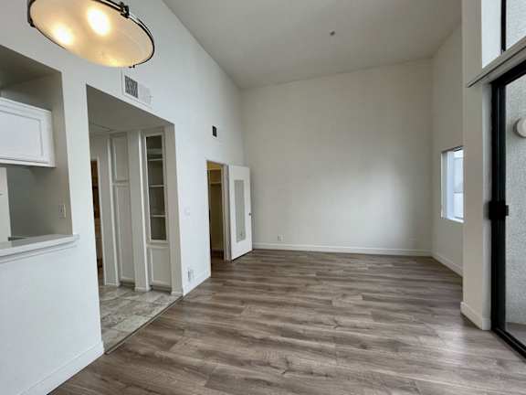 A room with a light on the ceiling and a door on the right.