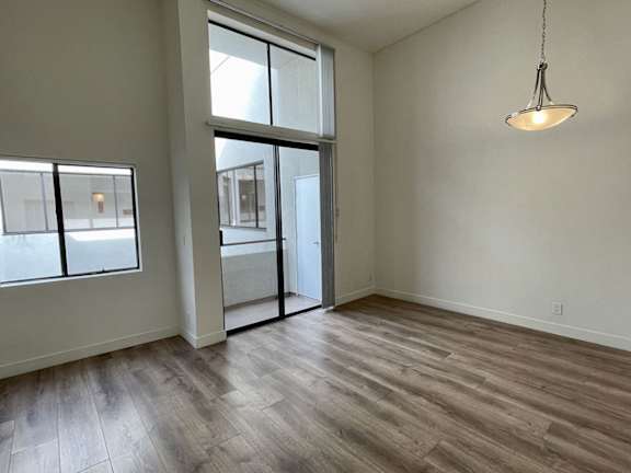 A room with a wooden floor and a hanging light fixture.