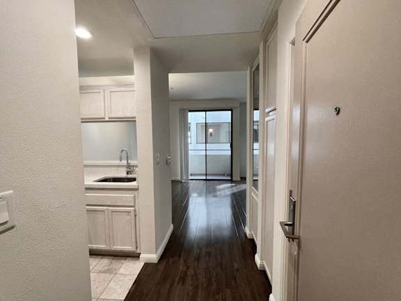 A long hallway with a kitchen area on the left.