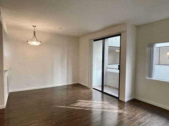 A room with a wooden floor and a hanging light fixture.