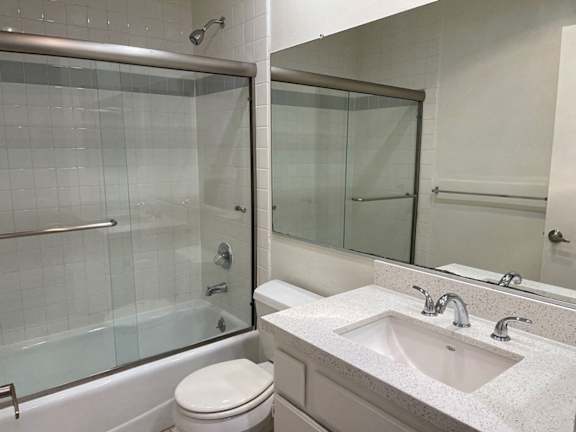 A white toilet sits next to a sink in a bathroom.