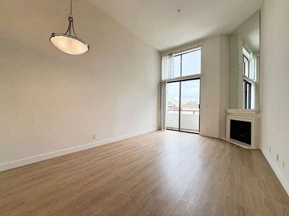 A large empty room with a fireplace and a large window.