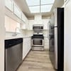 A modern kitchen with a dishwasher, oven, and refrigerator.