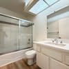 A white toilet sits in a bathroom with a white sink.