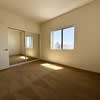 A room with brown carpet and a window.
