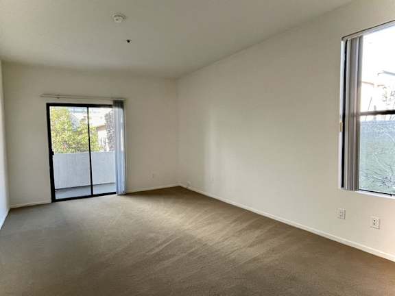 A room with a sliding glass door leading to a balcony.