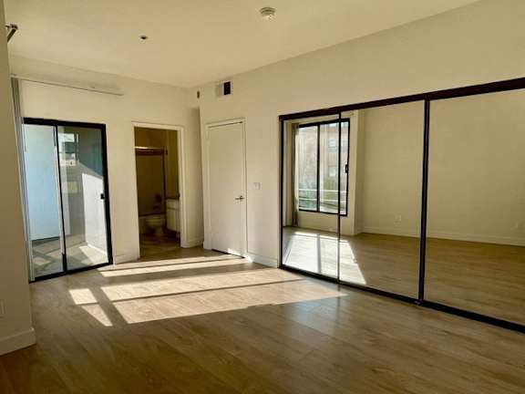 A room with a sliding glass door and a rug on the floor.
