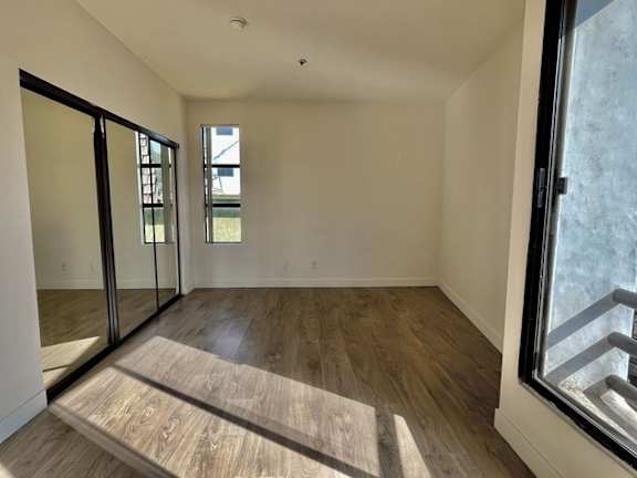 A room with wooden flooring and a window.