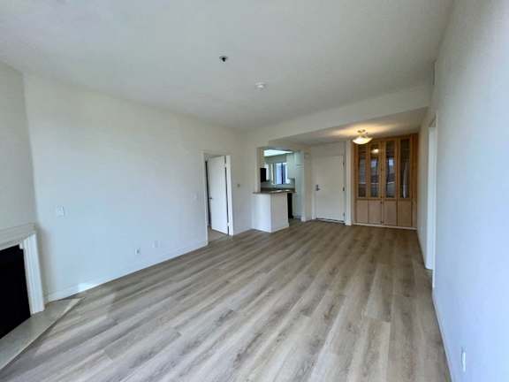 A room with a fireplace and wood flooring.