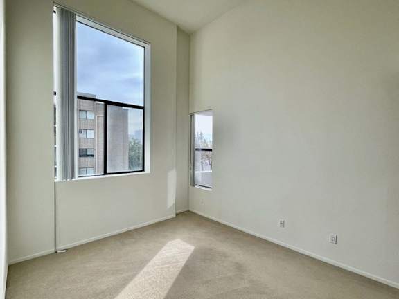 A room with a large window and a carpeted floor.