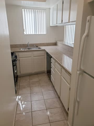 A kitchen with white appliances and cabinets.