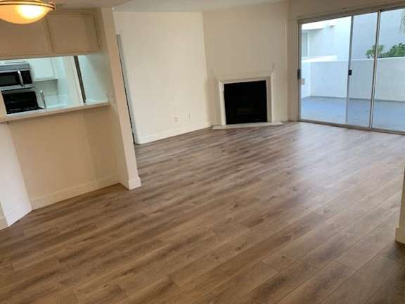 A room with a fireplace and wooden flooring.