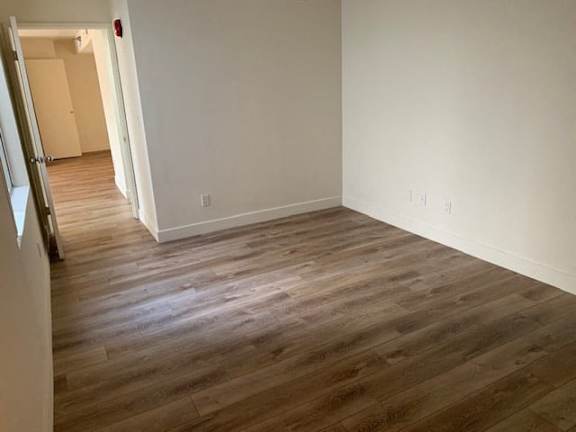 A room with wooden flooring and white walls.