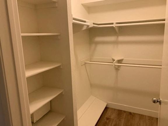A white refrigerator with its door open and empty shelves.