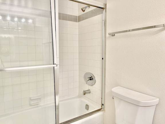 A white toilet is next to a glass shower stall.