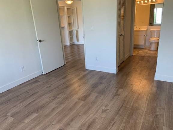 A room with wooden flooring and white walls.