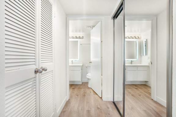 A white bathroom with a toilet, sink, and mirror.