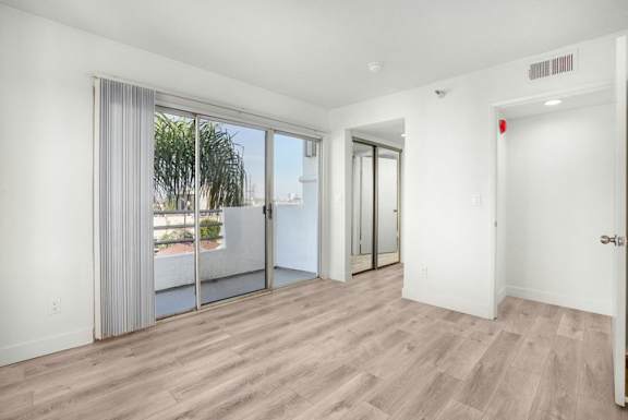 A room with a sliding glass door leading to a balcony.