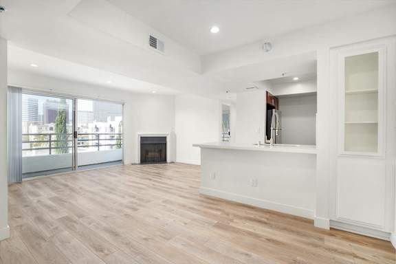 A spacious living room with a fireplace and a large window.