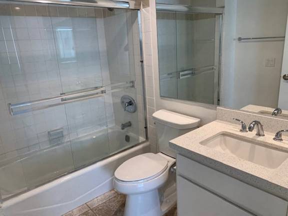 A white toilet sits next to a sink in a bathroom.