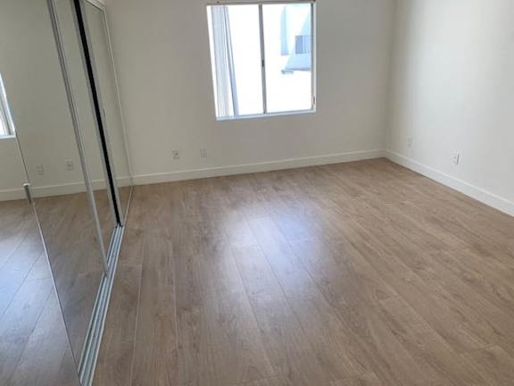 A room with wooden flooring and a window.