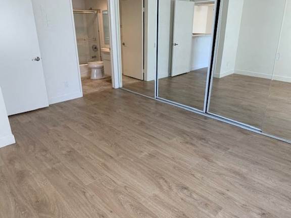 A room with a wooden floor and a white door.