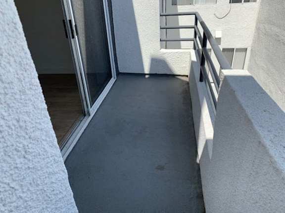 A balcony with a glass door and a metal railing.