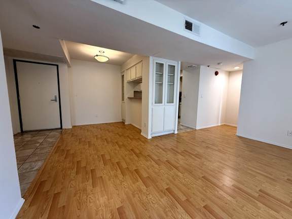 A room with wooden flooring and a white door.