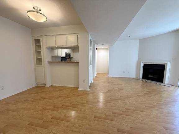 A spacious living room with a fireplace and hardwood floors.
