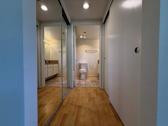A bathroom with a toilet, sink, and mirror.