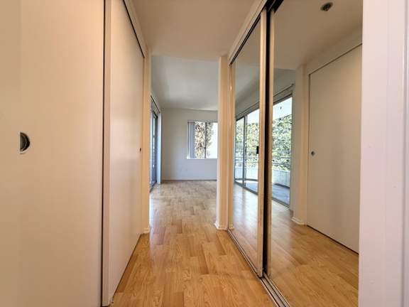 A hallway with a wooden floor and white walls.