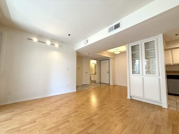 A room with wooden flooring and white walls.