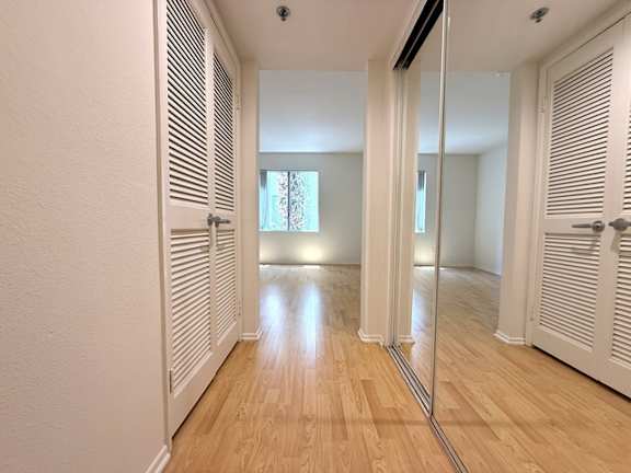 A hallway with wooden floors and white walls.