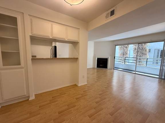 A room with wooden floors and a white fridge.