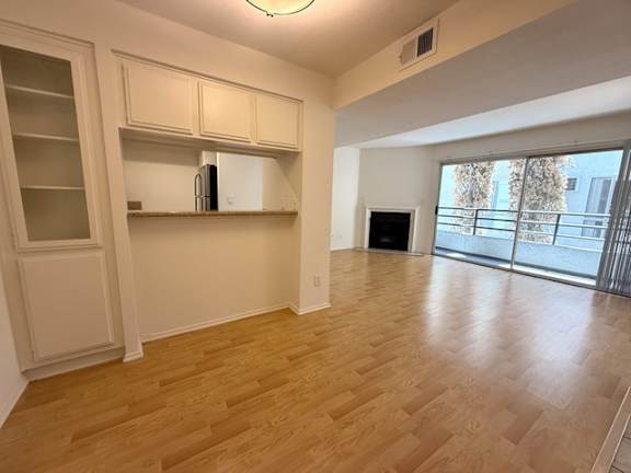 A kitchen with wooden floors and white cabinets.