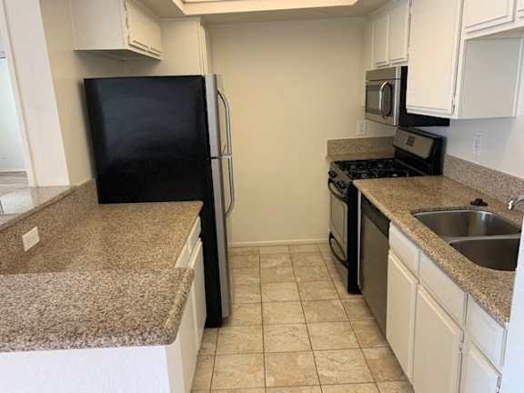 A kitchen with black appliances and granite countertops.