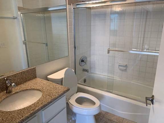 A bathroom with a toilet, sink, and shower.