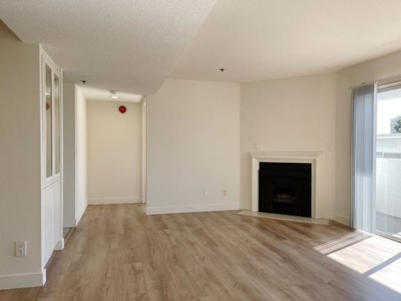 A room with a fireplace and wooden floors.