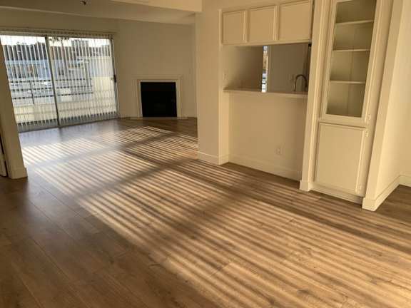 A room with wooden flooring and white walls.
