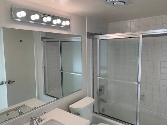 A bathroom with a toilet, sink, and shower.