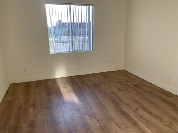 A room with wooden flooring and a window.