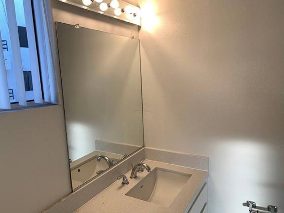 A bathroom with a sink and mirror.