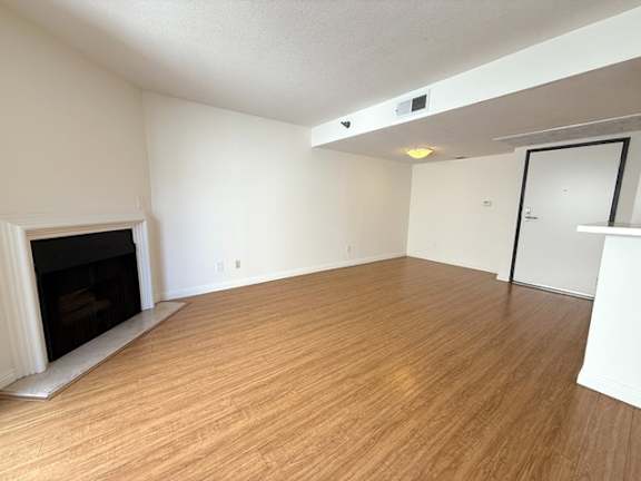 A room with a fireplace and wooden flooring.