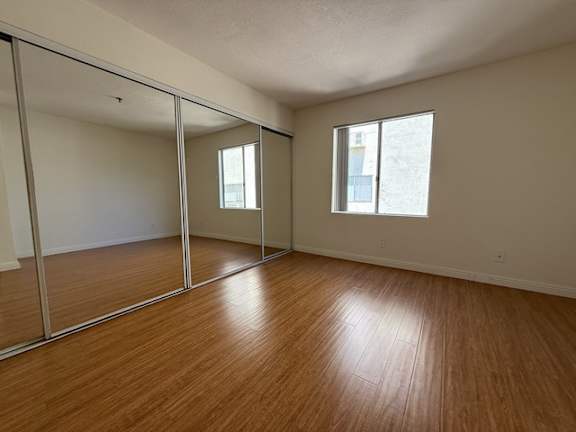 A room with wooden floors and a large mirror.