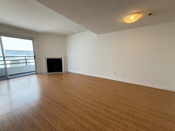 A room with a fireplace and a sliding glass door.