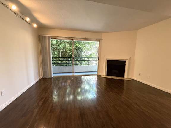 A room with a fireplace and sliding glass doors.