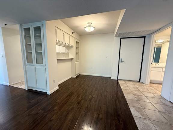 A kitchen with white cabinets and a wooden floor.