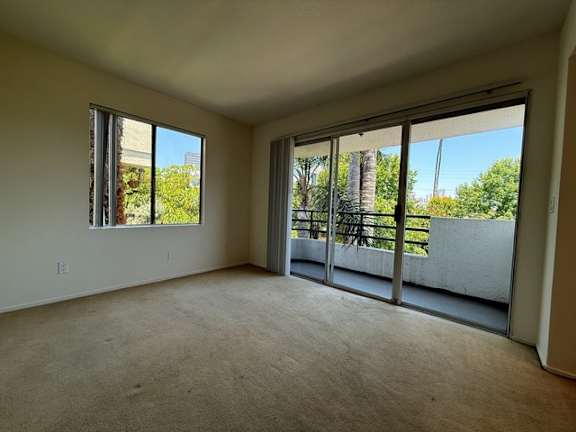 A room with a large window and sliding glass doors.